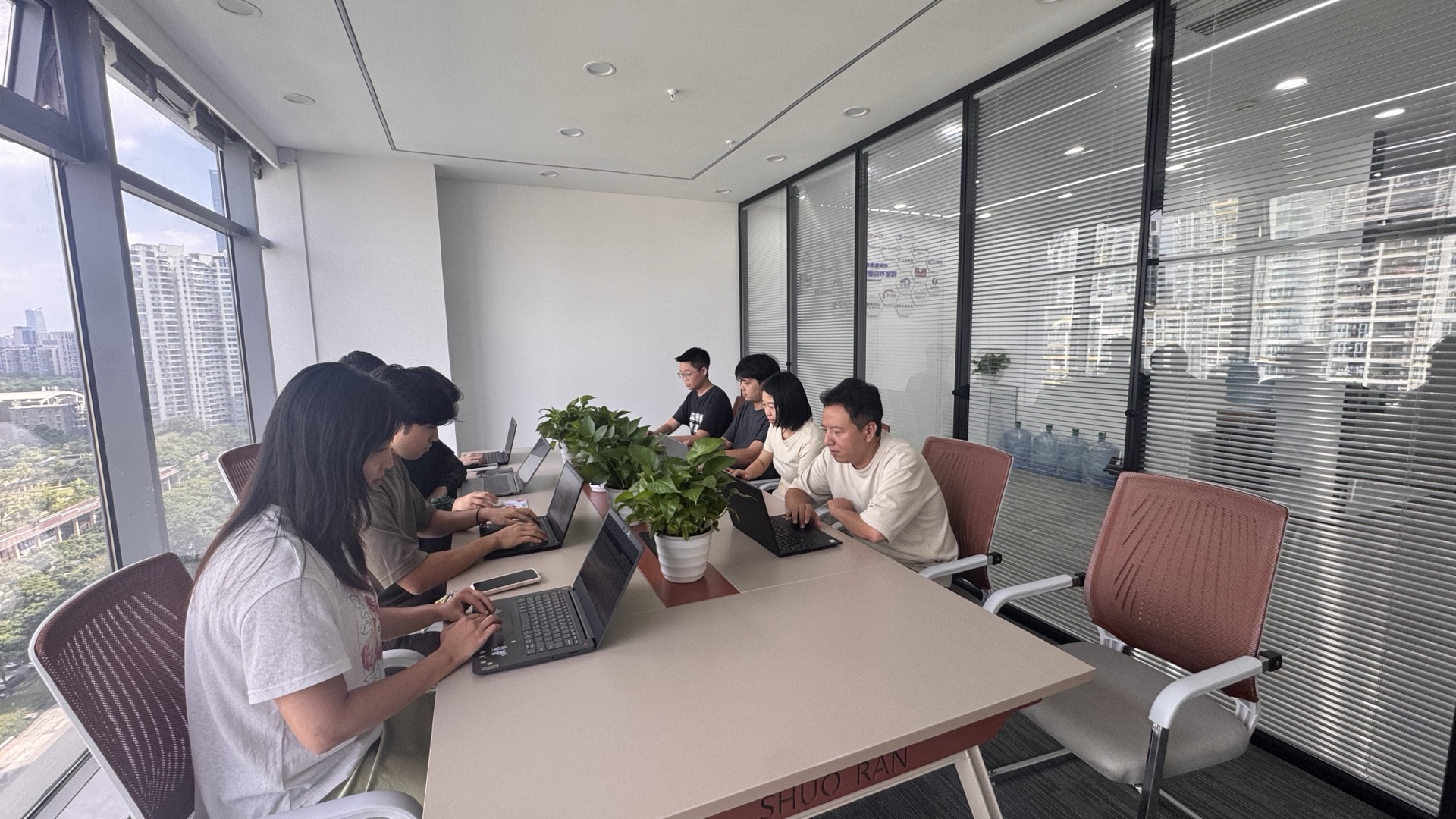 九序团队在会议室开项目例会，每人面前放着笔记本电脑